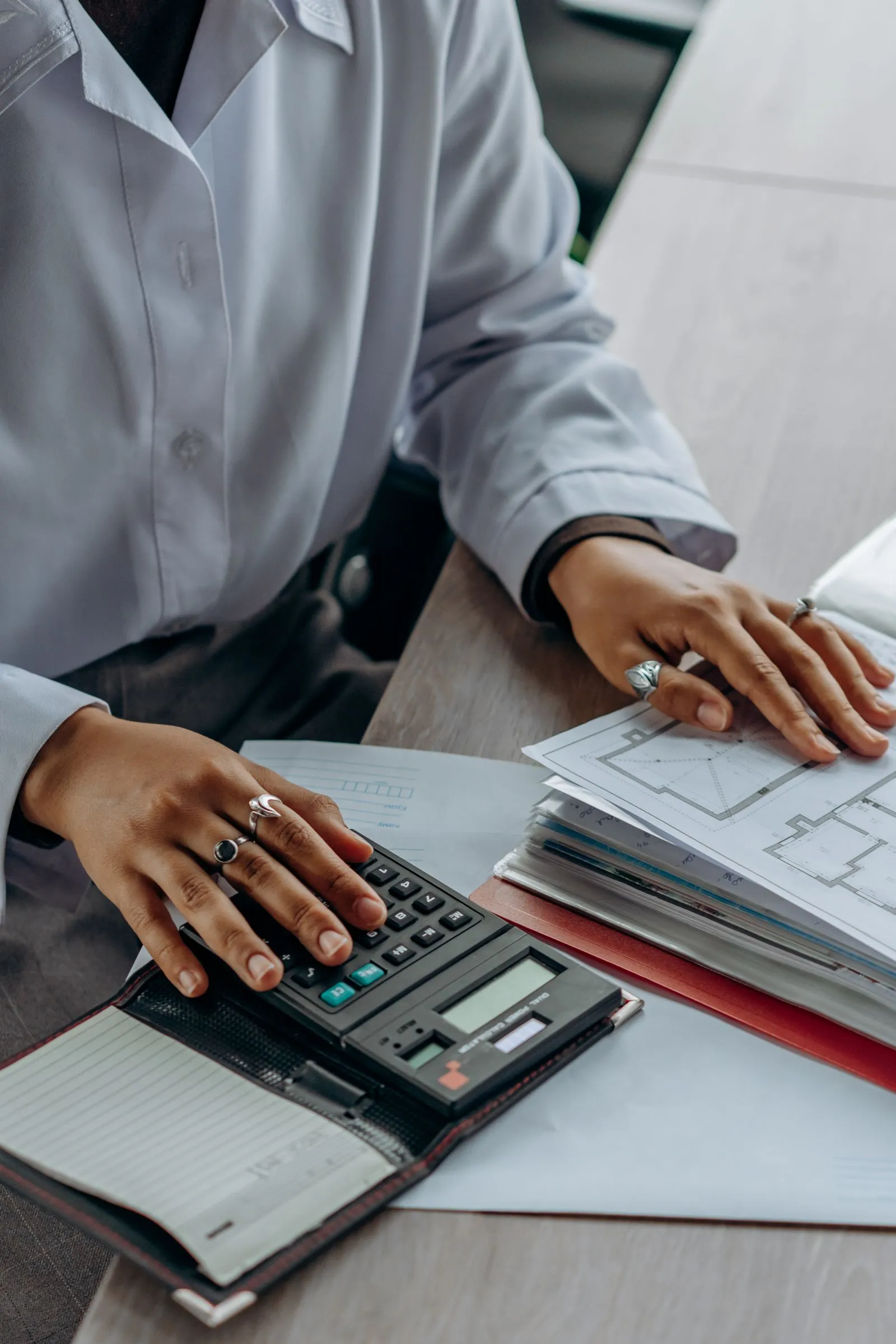 A bookkeeper working through documents with a calculator