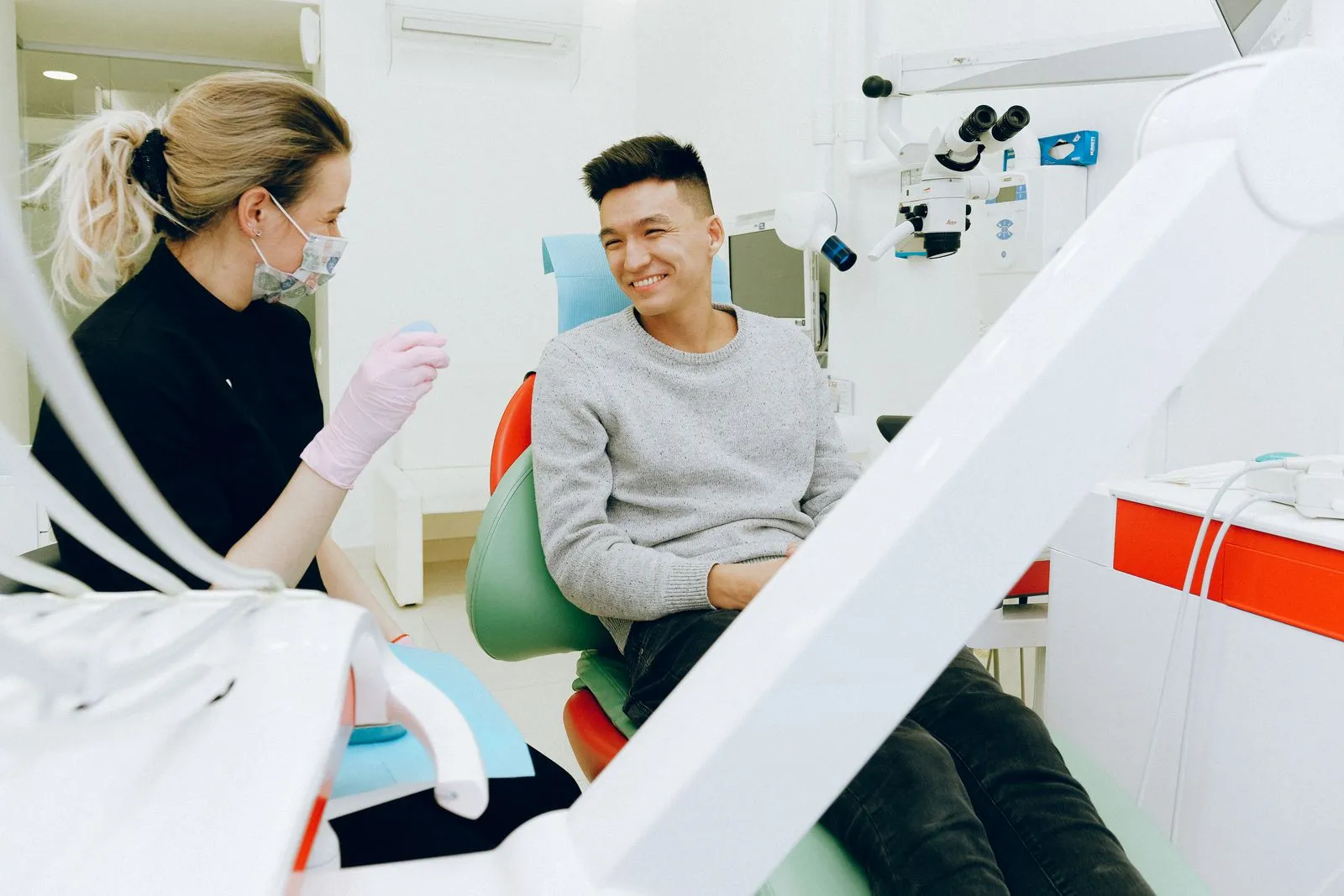 A smiling patient in the dental chair chatting with his dentist