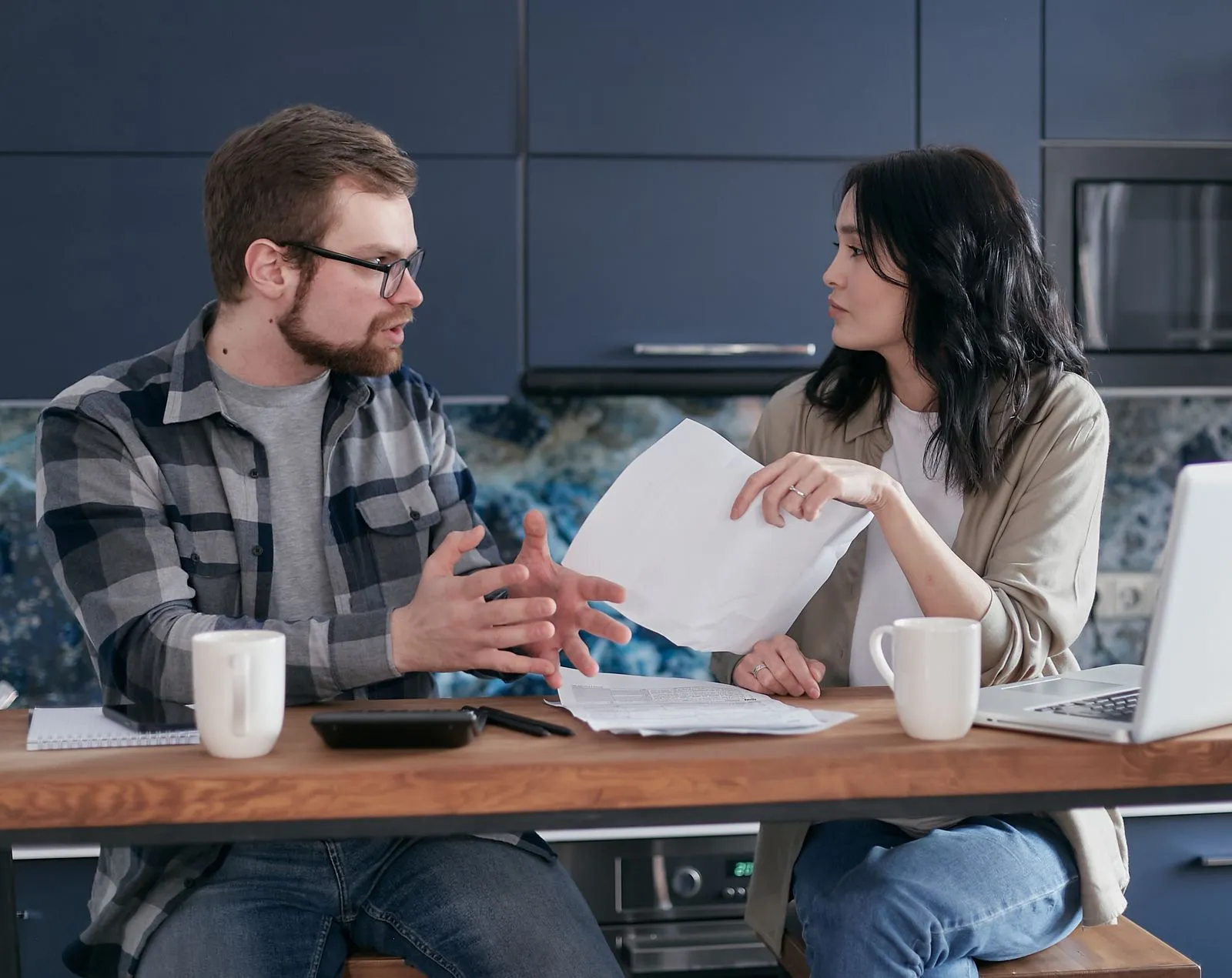 A couple talking through tax documents at their kitchen table